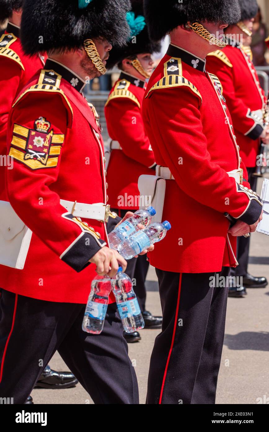 The Mall, London, Großbritannien. Juni 2024. Die Band of the Irish Guards erhält Flaschen mit Wasser, während sie in 30 Grad Hitze an der Mall stehen, dem heißesten Tag des Jahres, vor der Kutschenprozession nach einer feierlichen Begrüßung bei der Horse Guards Parade beim Besuch des japanischen Bundesstaates in Großbritannien. Quelle: Amanda Rose/Alamy Live News Stockfoto