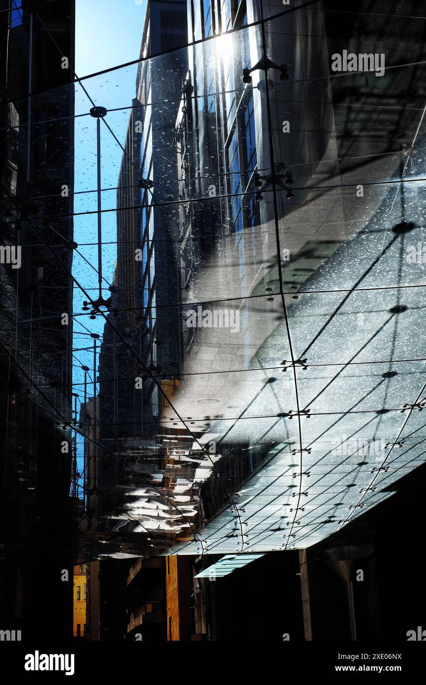 Blick nach oben durch eine Markise aus Glaspaneelen, eine Glasdecke über der plaza am Aurora Place in der Phillip Lane, Schatten, geometrische Formen, Reflexionen. Stockfoto