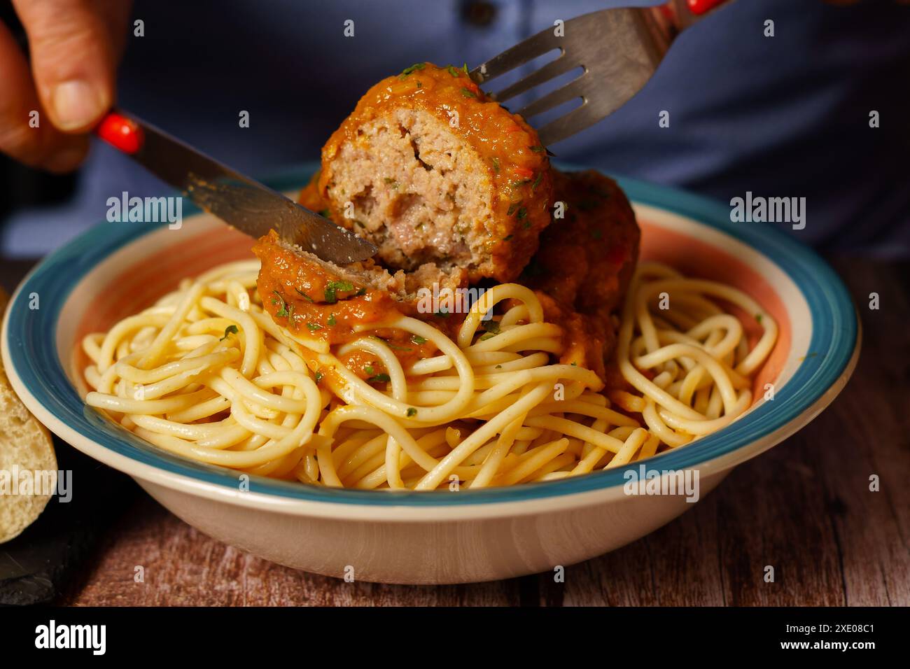 Nahaufnahme eines Tellers Fleischbällchen mit Spaghetti mit Besteck Stockfoto