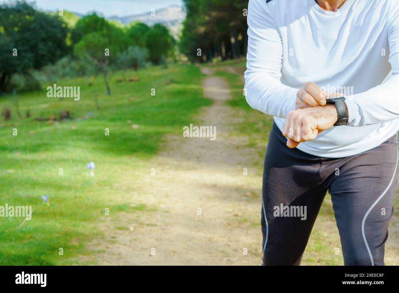 Mann trainiert mit seiner Smartwatch im Feld Stockfoto