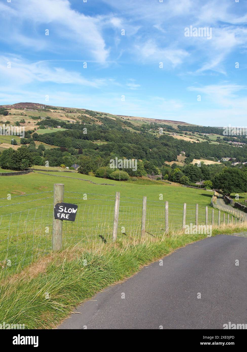 Schmale Landstraße im calder Valley in der Nähe der hebden Bridge mit hausgemachtem Straßenschild langsam vor calderdale W Stockfoto