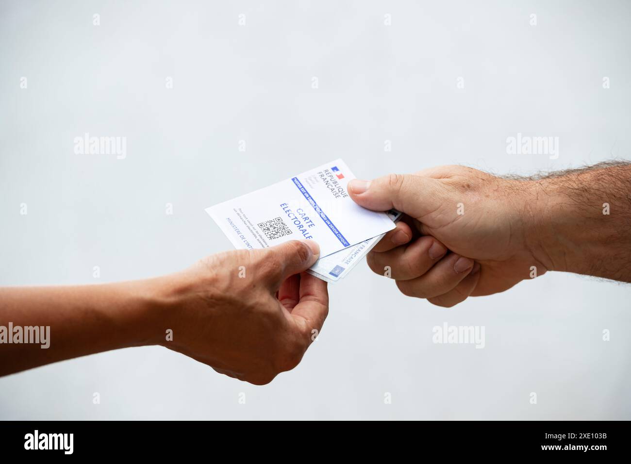 Frau, die einem Mann einen französischen Wahlausweis und Personalausweis gibt, Wahlen in Frankreich Stockfoto