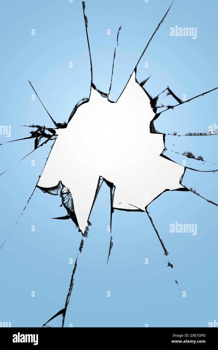 Glasscherben mit einem Loch in der Mitte auf blauem Hintergrund. Die Struktur der Risse, die Wirkung der Zerstörung des Stockfoto