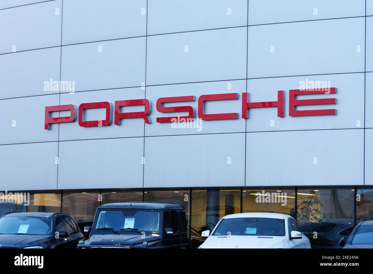 Tyumen, Russland, 18. März 2024: Fahrzeuge, die vor einem Porsche-Händlerbetrieb geparkt werden, zeigen Luxusautos und das ikonische Porsche-Logo. Stockfoto