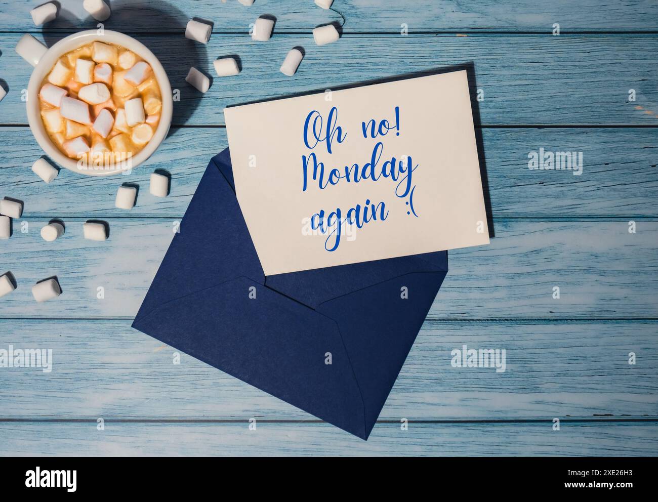 OH NEIN MONDAY AGAIN Konzepttext blauer Umschlag mit weißer Tasse Kaffee und Marshmallows auf hölzernem Hintergrund. Die meisten Depressin Stockfoto