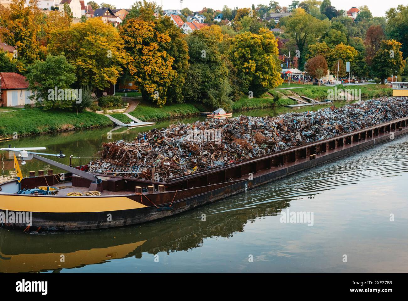 Transportindustrie. Schiffskahn transportiert Schrott und Sand mit Kies. Der mit Metallschrott beladene Lastkahn ist auf der Straße Stockfoto