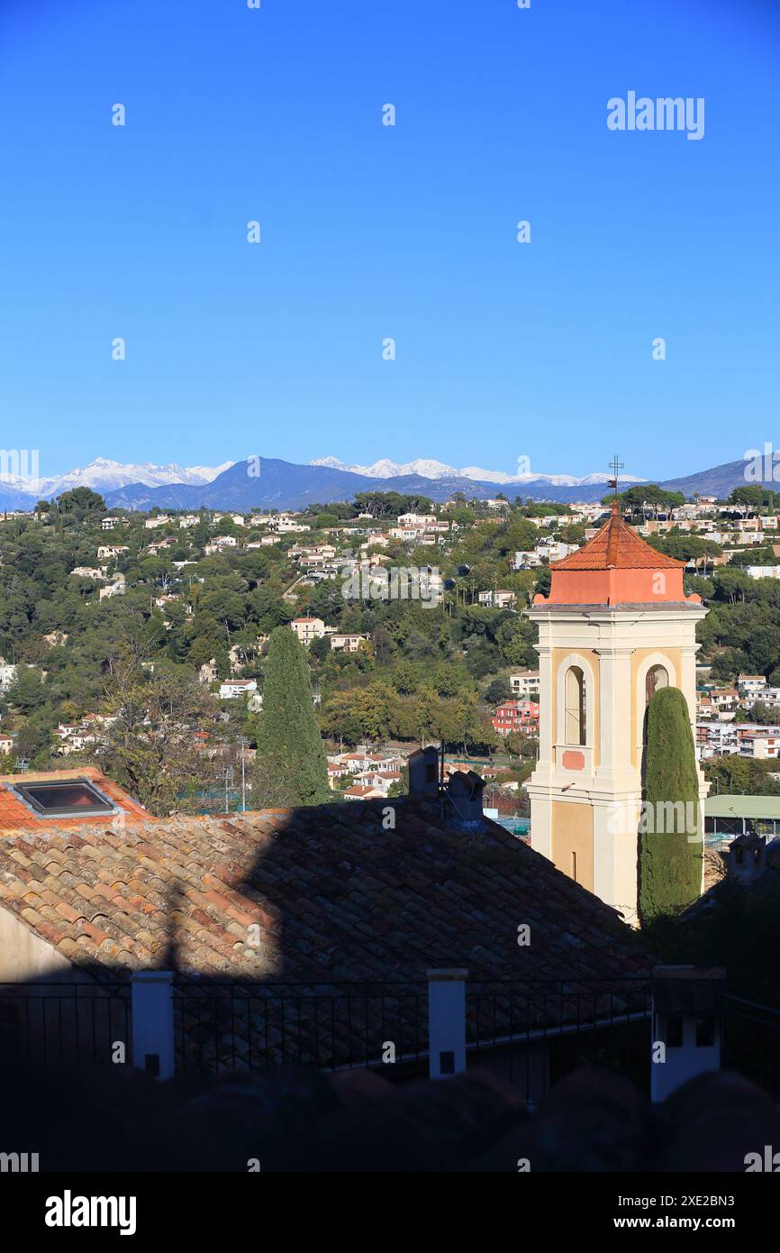 Kirche des Dorfes Cagnes sur Mer mit dem schneebedeckten Berg im Hinterland, Alpes Maritimes, französische Riviera Stockfoto