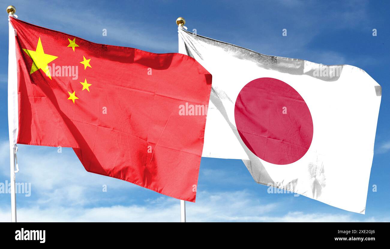 Chinesische Flagge und japanische Flagge am bewölkten Himmel. Im Himmel winken Stockfoto