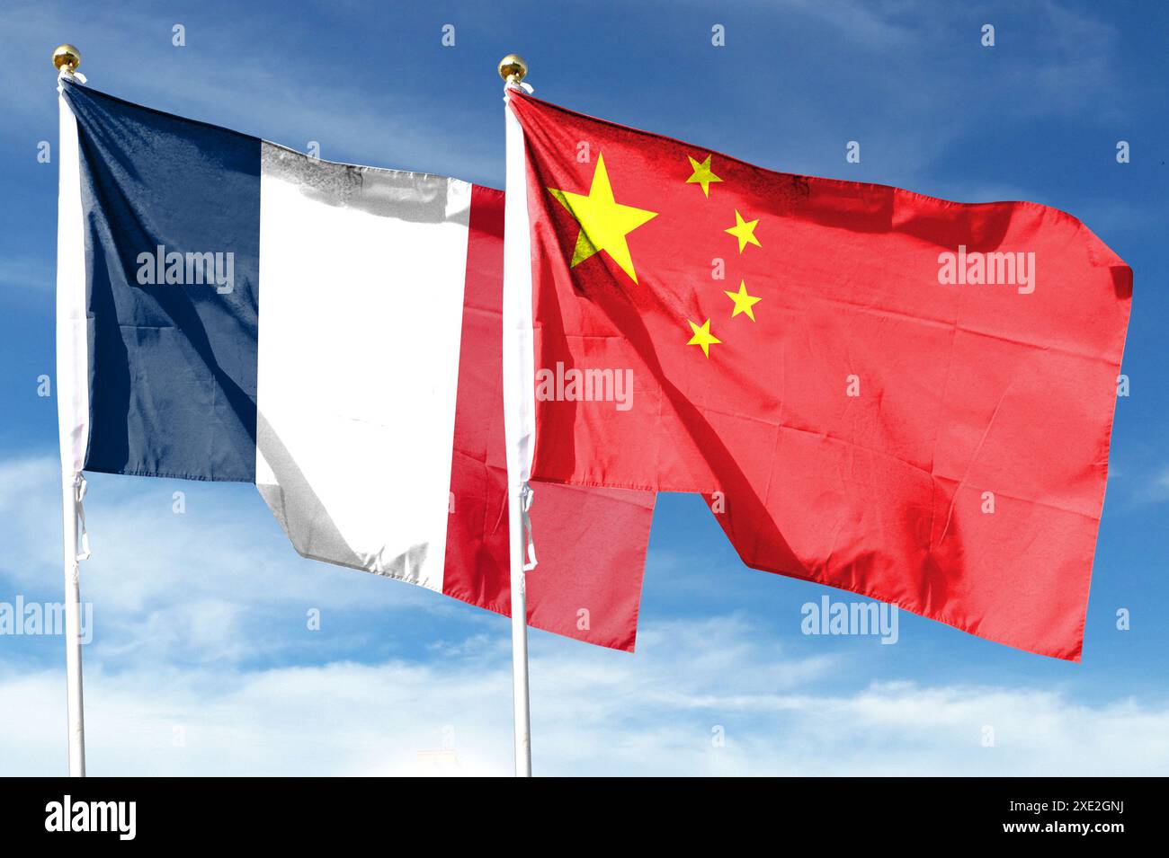 Chinesische Flagge, französische Flagge unter bewölktem Himmel. Fliegen in den Himmel Stockfoto