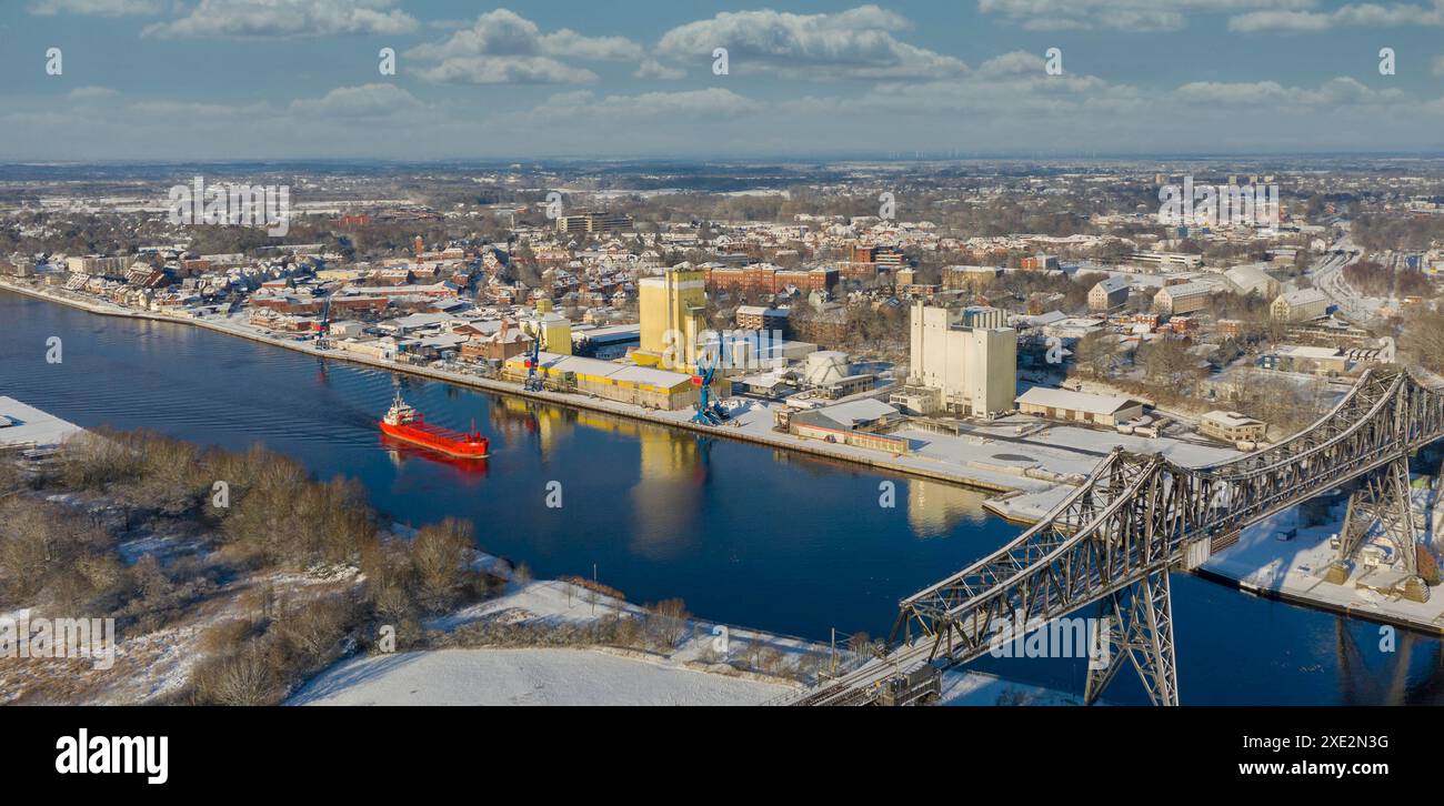 Panoramablick auf die berühmte Rendsburger Hochbrücke mit Frachtschiff mit Schnee und Frost Stockfoto