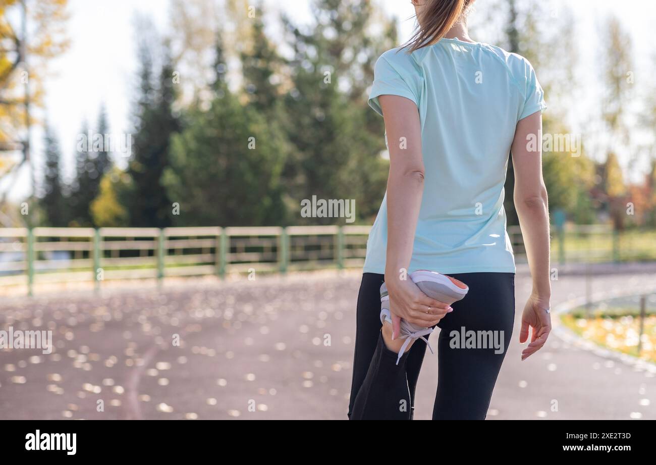 Eine junge, schöne Frau in Sportbekleidung spielt Sport in einem Stadion Stockfoto