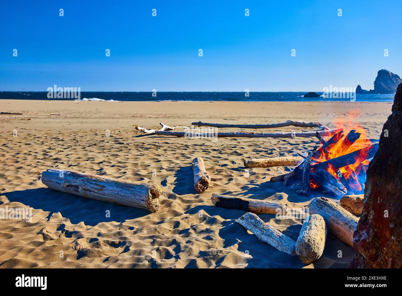 Lagerfeuer und Treibholz am ruhigen Oregon Beach auf Eye Level Stockfoto