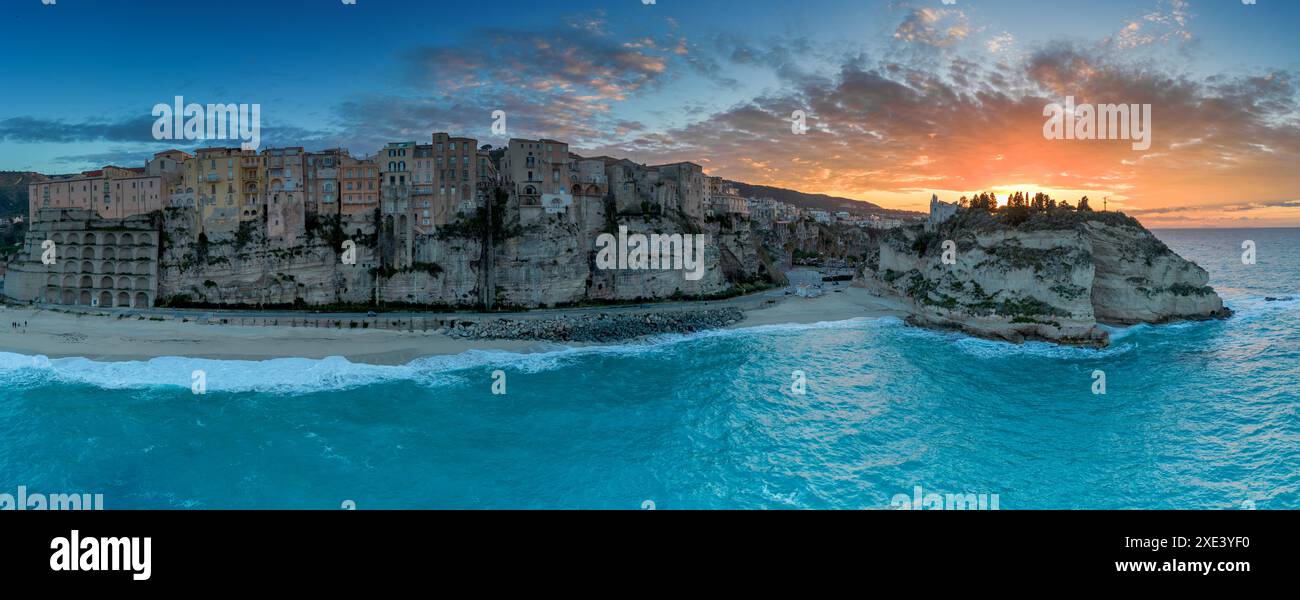 Blick auf Rotonda Beach und die farbenfrohe Altstadt von Tropea in Kalabrien bei Sonnenuntergang Stockfoto