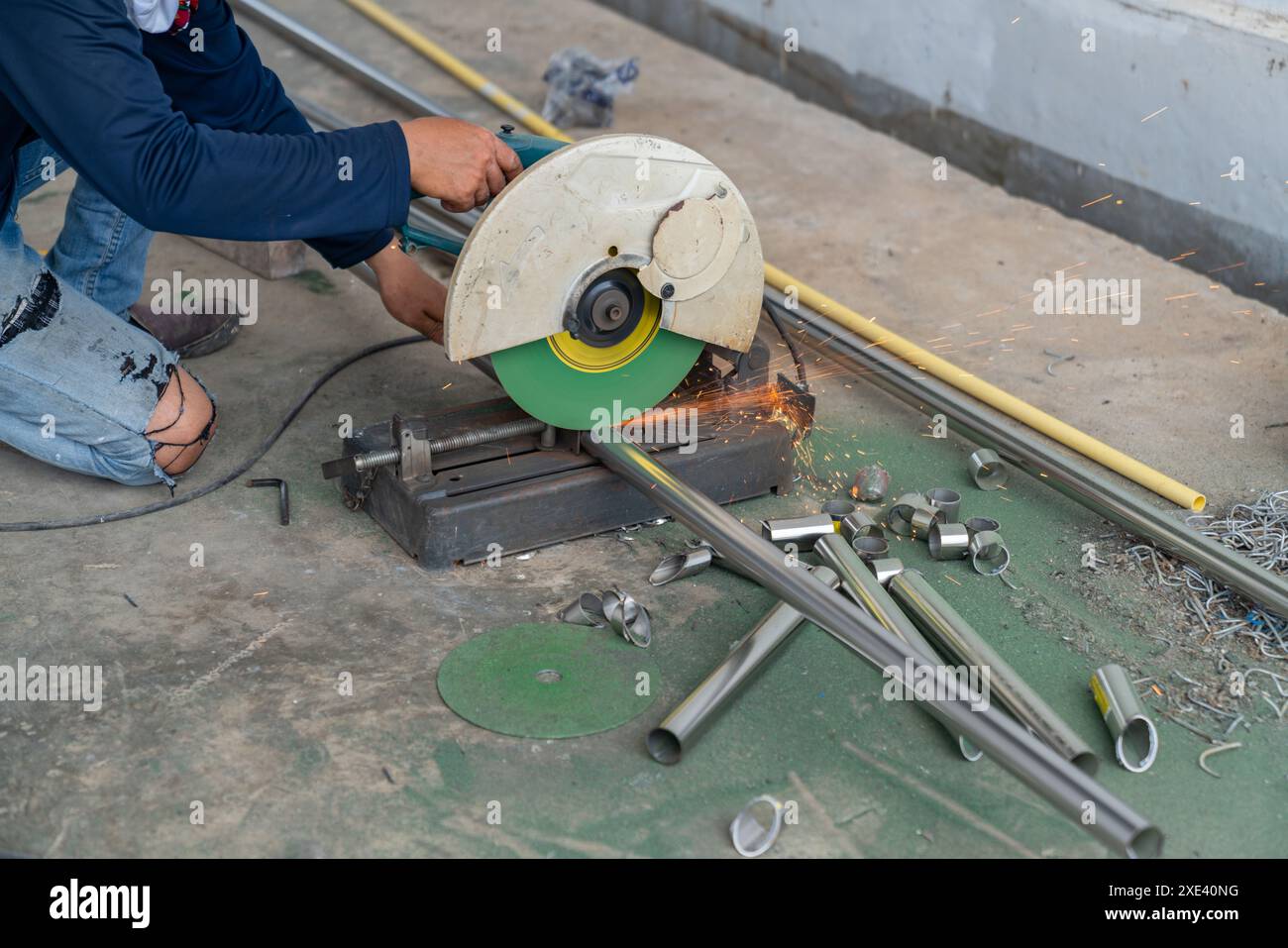 Die Faserkreisschneidemaschine schneidet quadratische Rohre aus Edelstahl. Elektrische Sägen zum Schneiden von Stahl. Schweißkonzept. Stockfoto