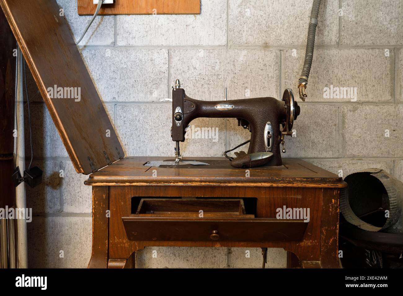 Eine weiße Drehmaschine Modell 43 mit Tisch im Keller eines Hauses. Das Haus wurde abgerissen Stockfoto