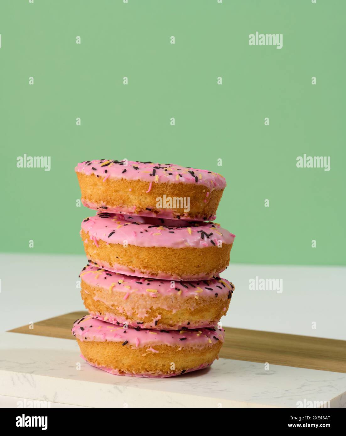 Donut bedeckt mit rosafarbener Glasur und mit bunten Streuseln bestreut Stockfoto