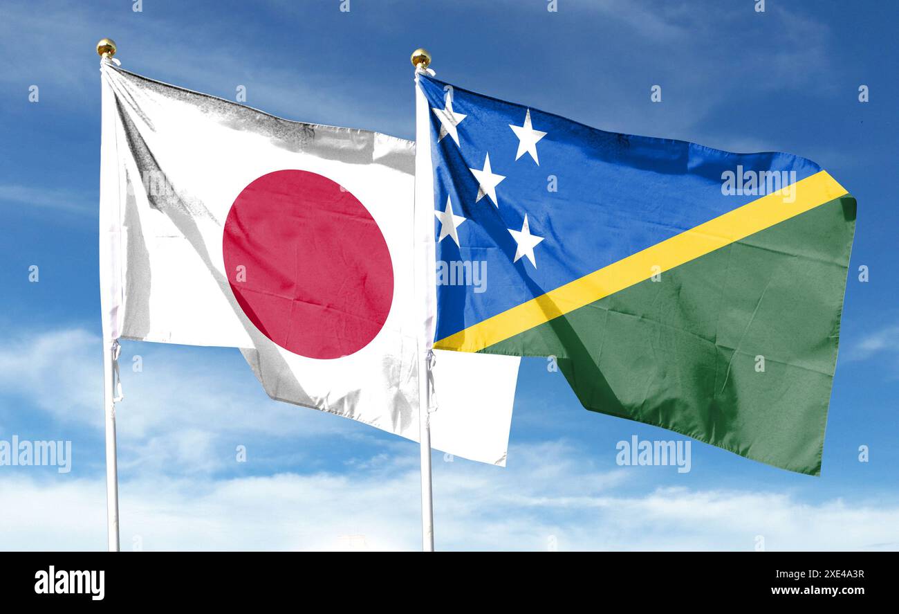 Japan-Flagge und Salomonen-Flagge am bewölkten Himmel. Im Himmel winken Stockfoto