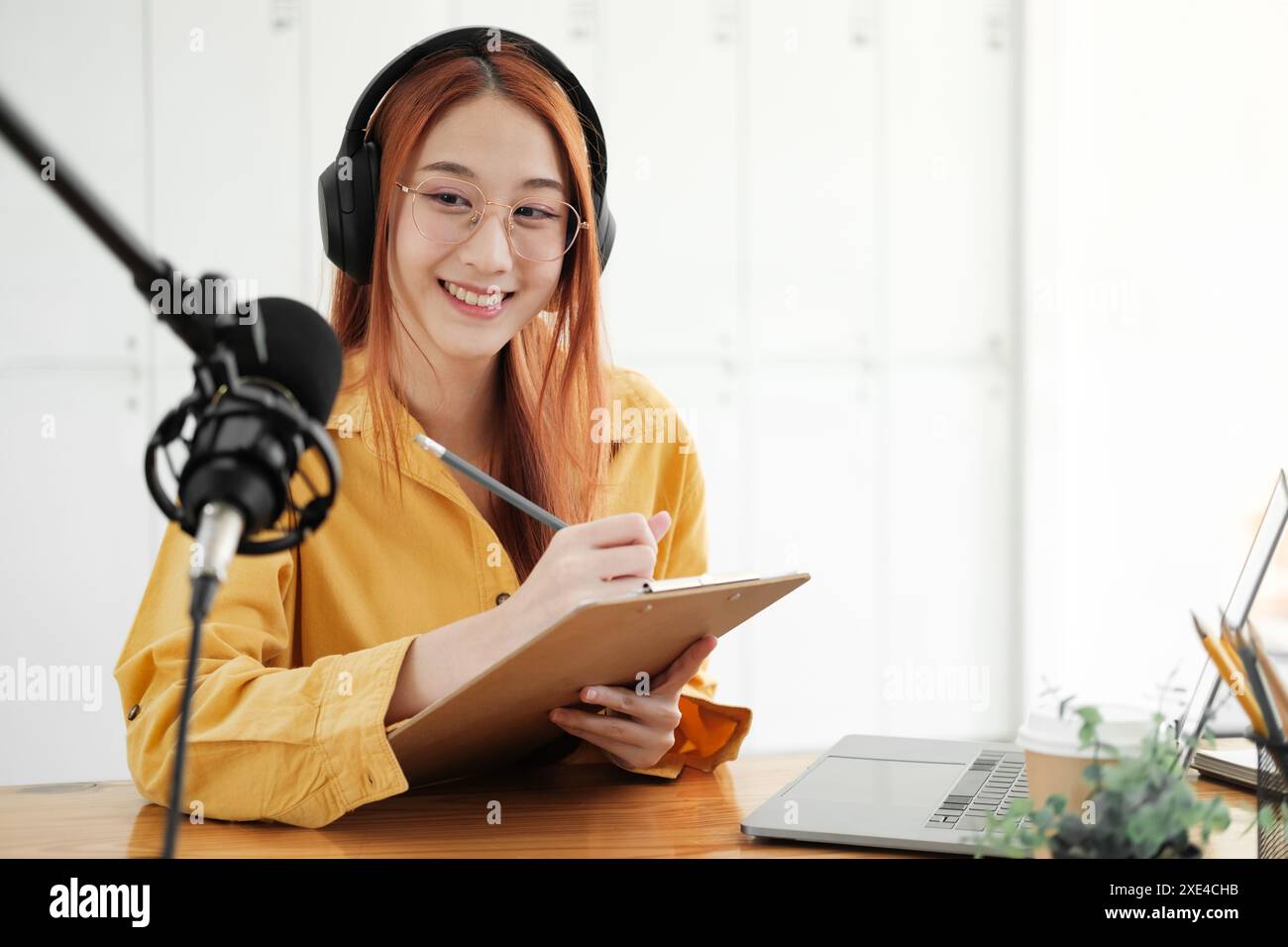 Live-Podcast-Session mit lächelnder weiblicher Moderatorin. Stockfoto