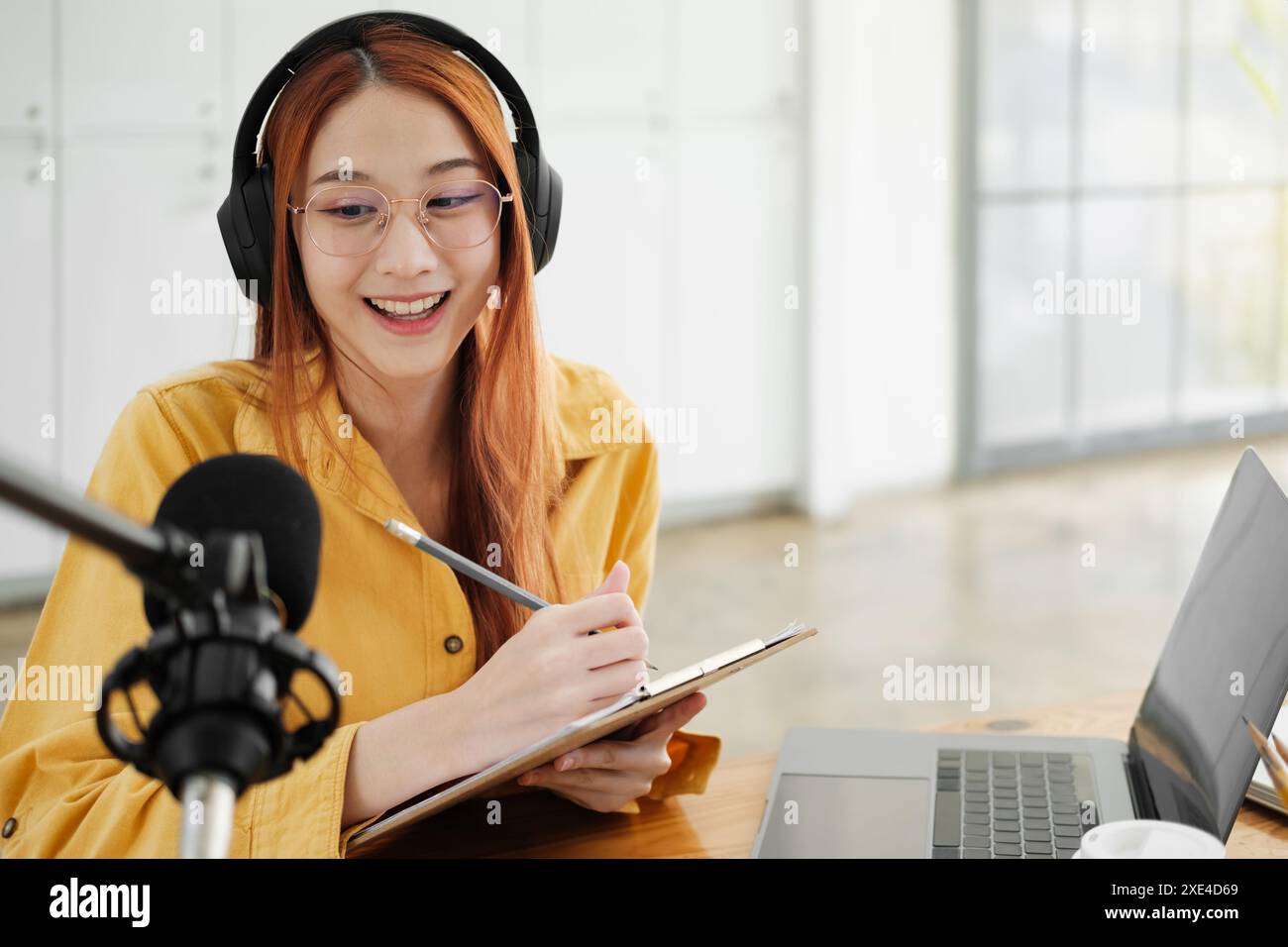 Live-Podcast-Session mit lächelnder weiblicher Moderatorin. Stockfoto