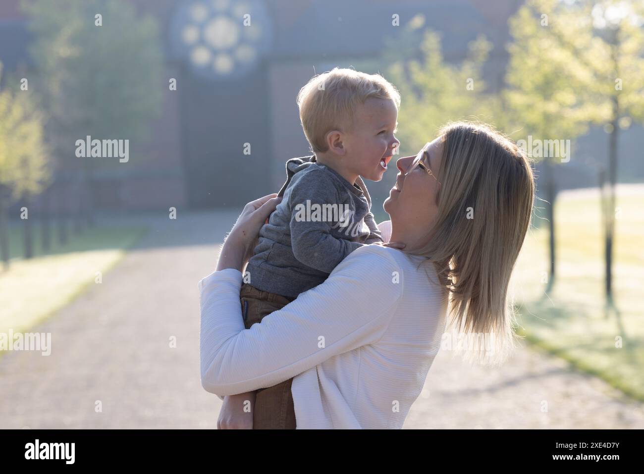 Lachen im Licht: Ein Morgen des Spielens Stockfoto