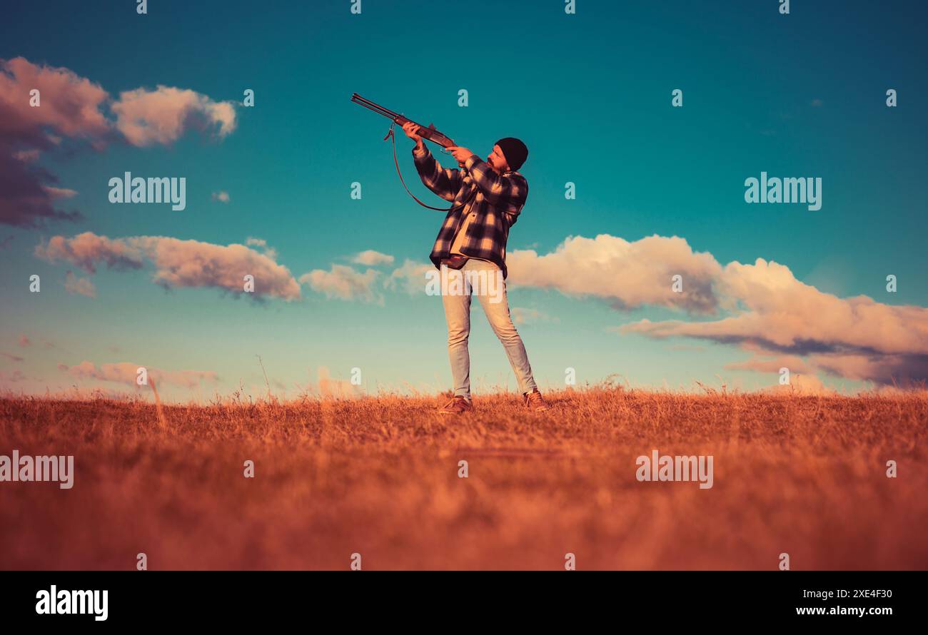 Sportliches Tonschießen und Skeet Shooting. Jäger mit Schrotflinte auf der Jagd. Autunm-Jagd. Jagd in den USA. Hunter zielt auf Gewehr im Wald. Prozess der Ente Stockfoto
