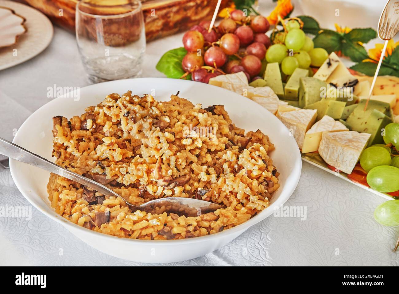 Nahaufnahme eines Löffels mit köstlichem Pilzrisotto in der Küche, das die cremige Textur und die herzhaften Zutaten hervorhebt. Stockfoto