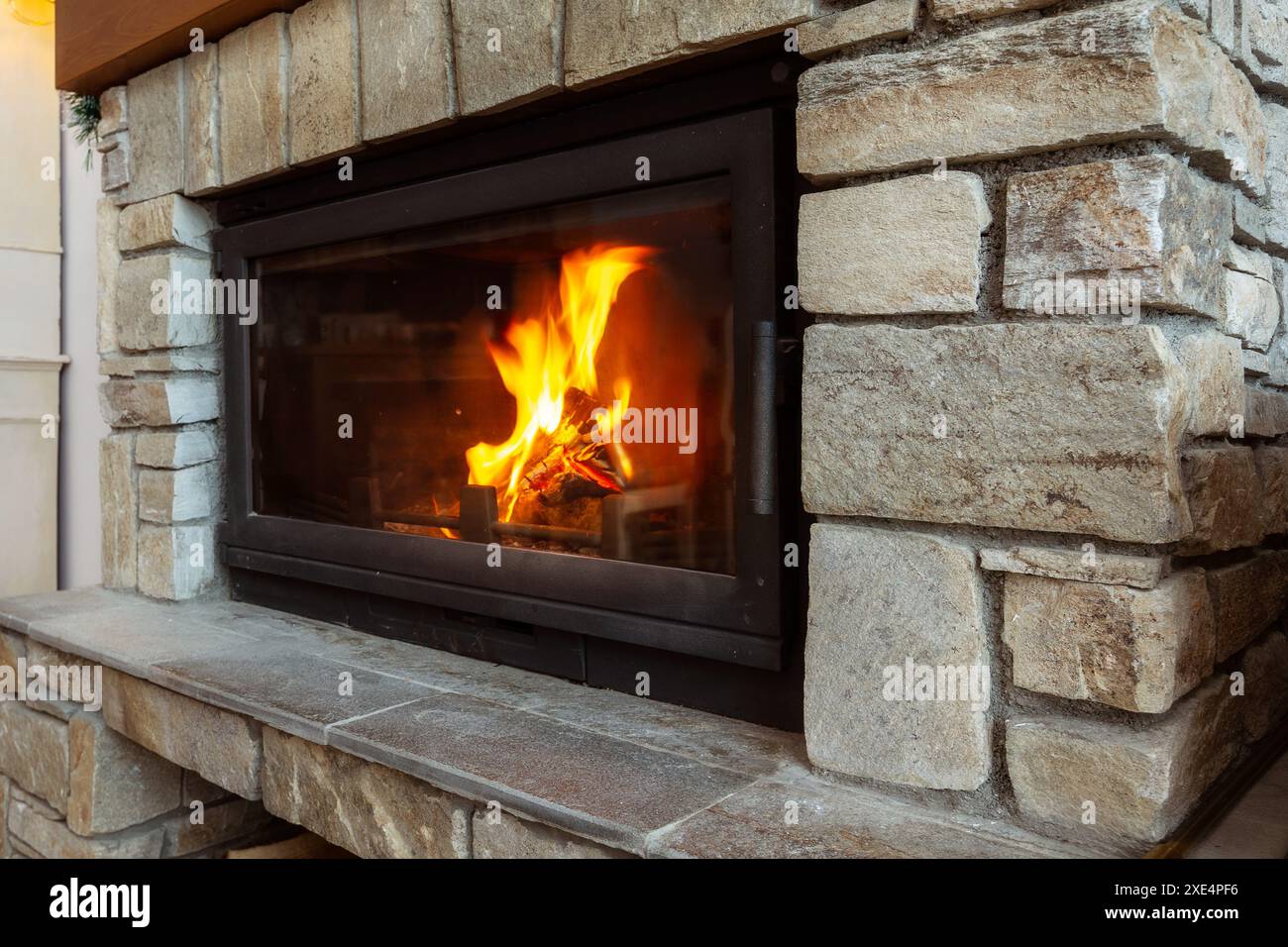 Steinkamin mit brennendem Feuer, gemütlicher Winter Stockfoto