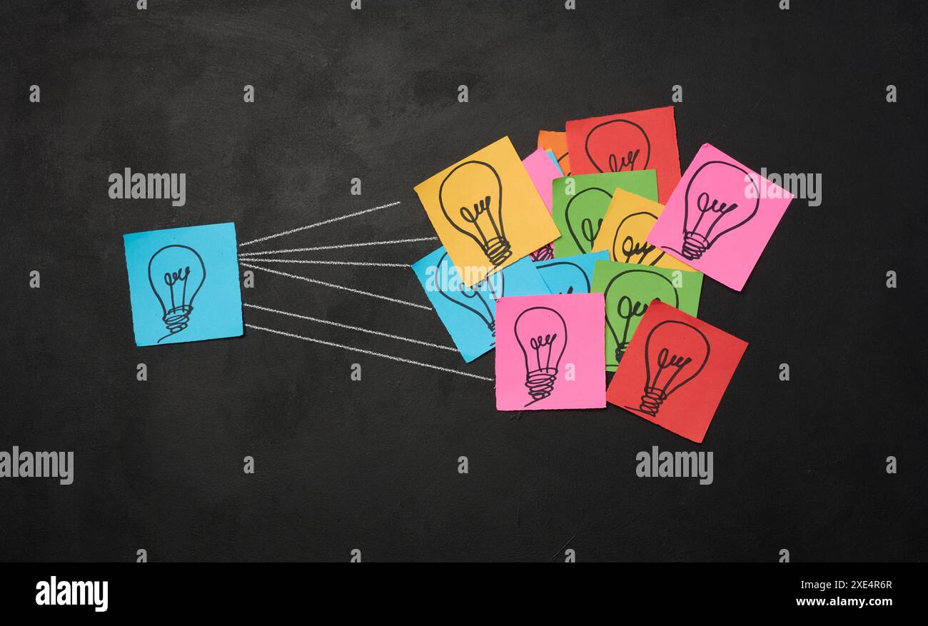 Gezeichnete elektrische Glühbirnen auf Papierbögen, die das Konzept der Suche nach neuen Ideen kennzeichnen. Stockfoto