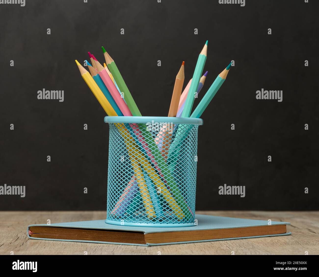 Mehrfarbige Holzstifte auf schwarzem Kreidetafelhintergrund Stockfoto