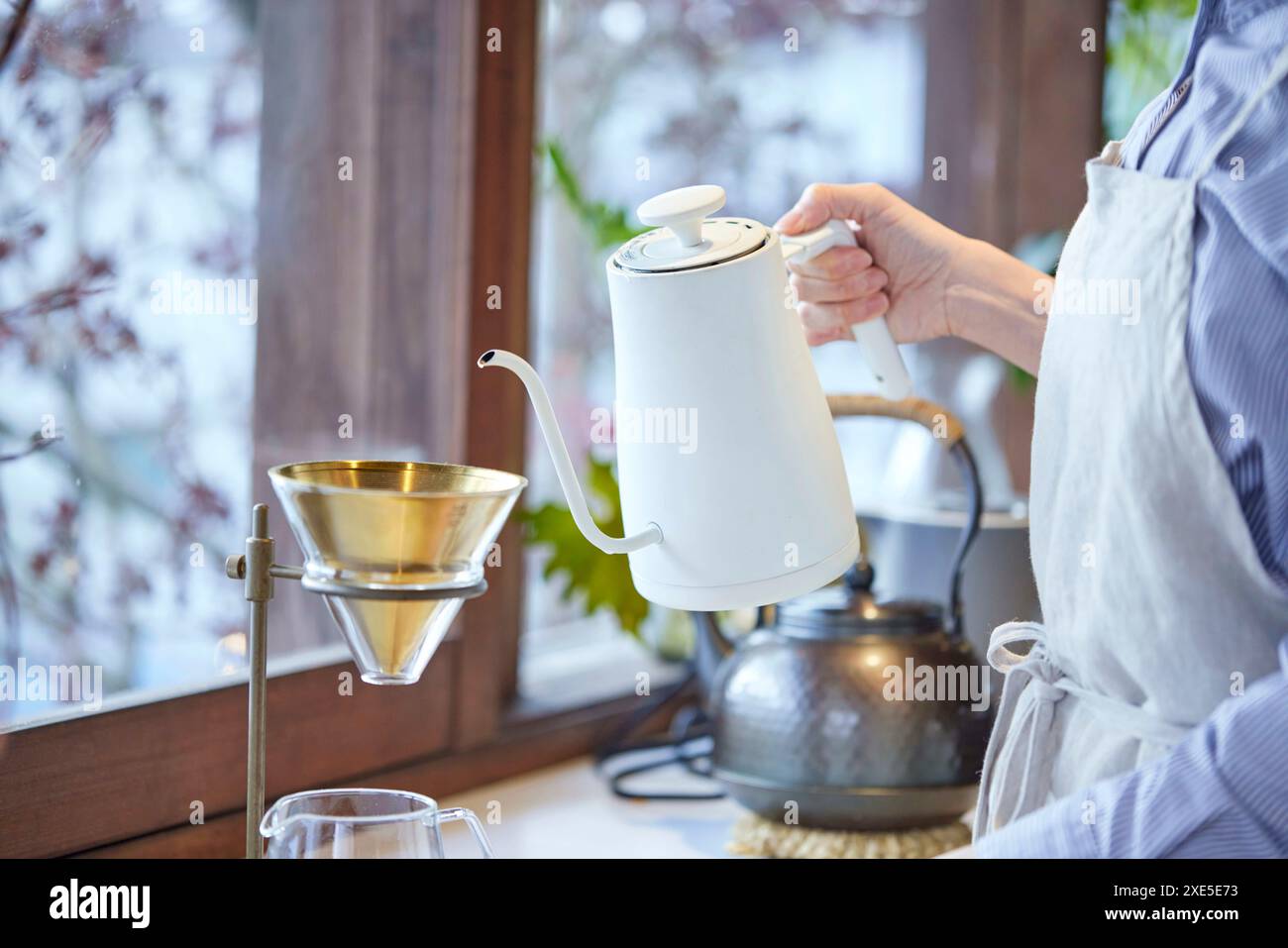 Junge Japanerin, die heißes Wasser gießt Stockfoto