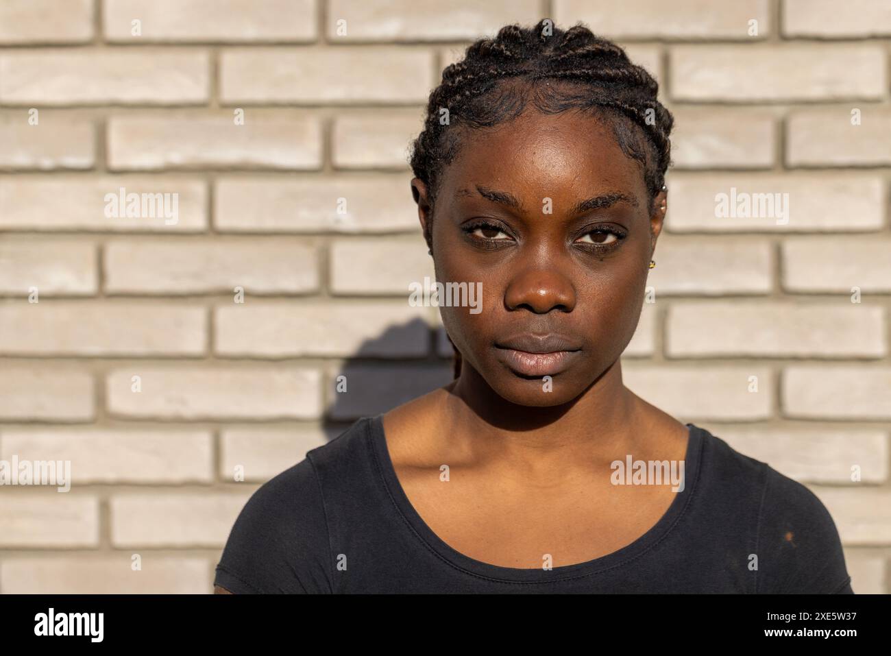 Selbstbewusste Junge Frau Gegen Brick Wall Stockfoto