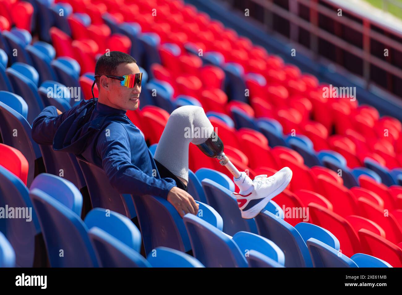 Behinderte Athleten bereiten ihre Körper an einem sonnigen Tag im Amphitheater in einer Sportarena vor, bevor sie zu einem Kurzstreckenlauf gehen Stockfoto