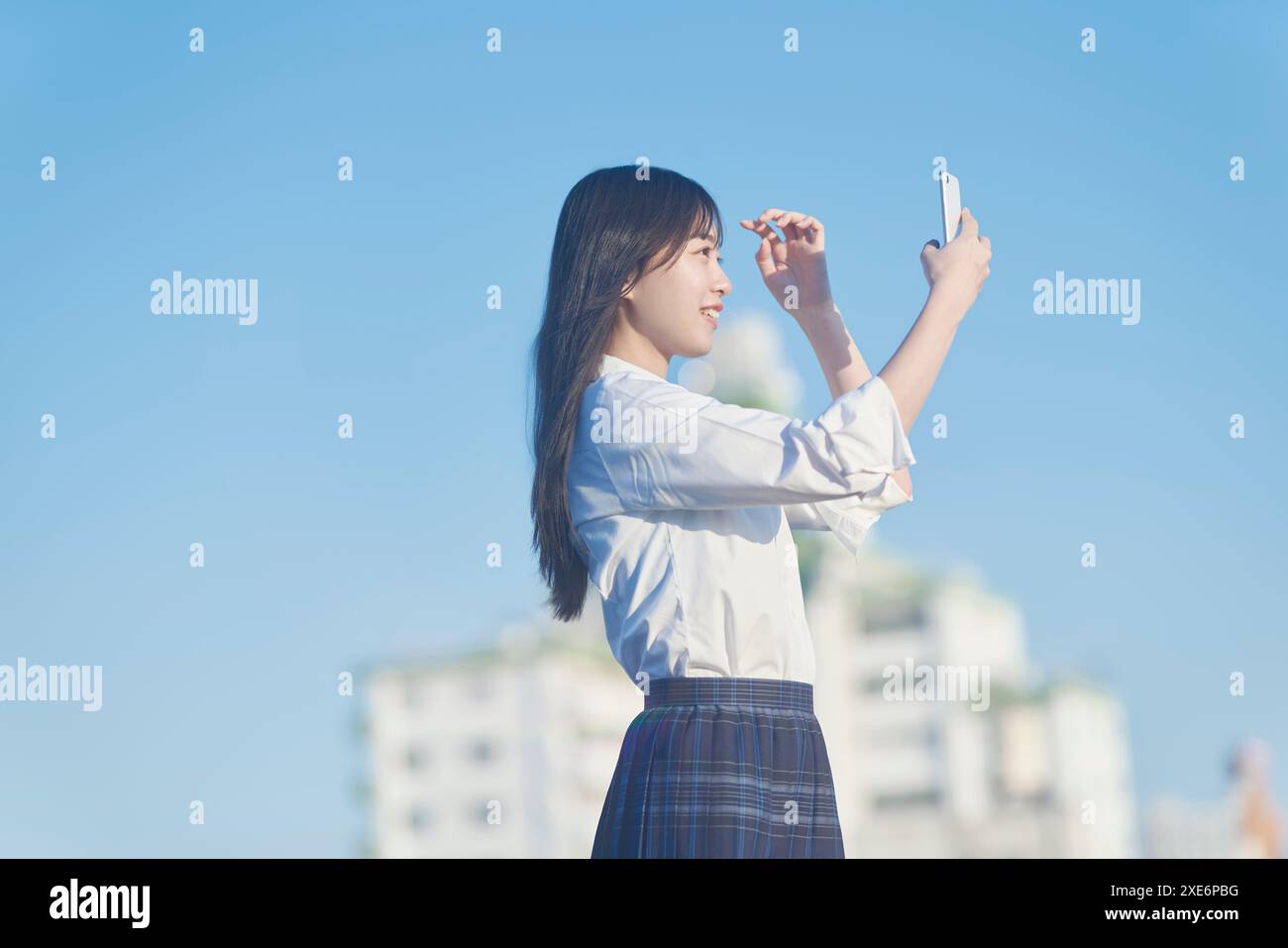 Eine Studentin, die eine Smartphone-Kamera auf dem Dach hält Stockfoto