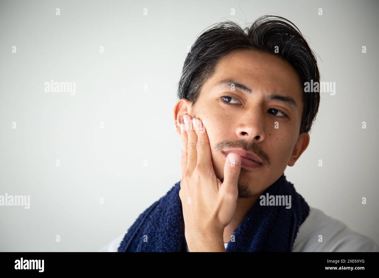 Ein Mann in seinen 30ern, der sich um seine Haut sorgt Stockfoto