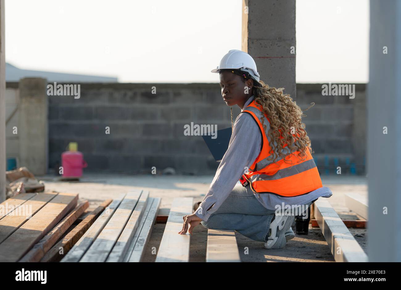 Junge Architektin, die auf einer Baustelle mit einem Laptop in der Hand arbeitet Stockfoto