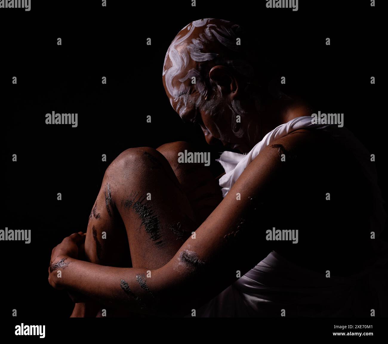 Rasierte und vernarbte Frau in dezenter Beleuchtung, die den Missbrauch schwarzer Frauen darstellt. Stockfoto