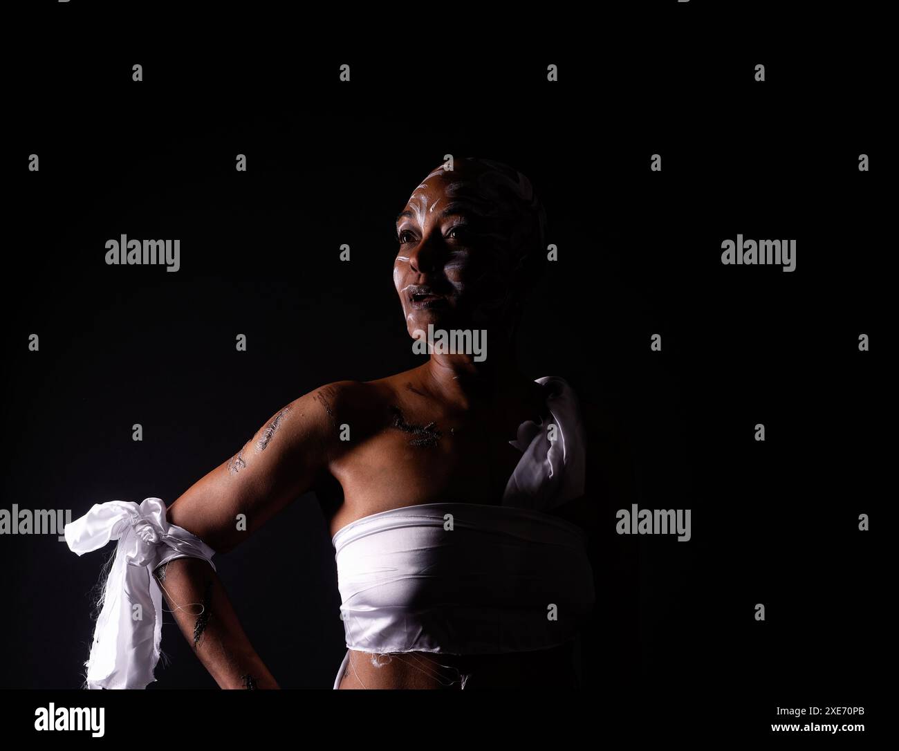 Rasierte und vernarbte Frau in dezenter Beleuchtung, die den Missbrauch schwarzer Frauen darstellt. Stockfoto