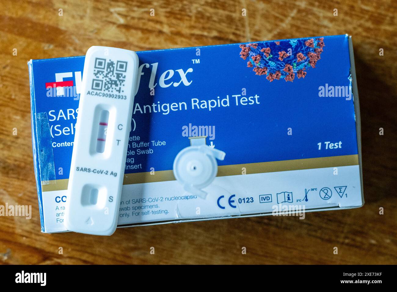 Positiver COVID-19-Test auf einem Holztisch. Stockfoto
