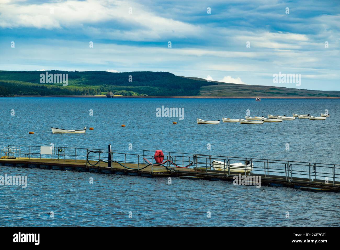 Leere Boote, die entlang eines Sees/Stausees treiben. Ruhiges Wasser. Hintergrund Wald/Wald. Großbritannien. UK. Stockfoto