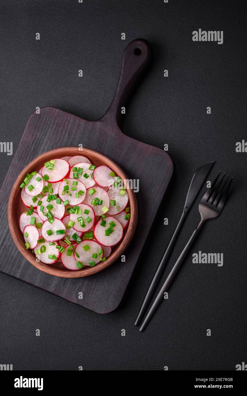 Köstlicher frischer Salat aus Radieschen in Scheiben mit grünen Zwiebeln, Salz und Olivenöl Stockfoto