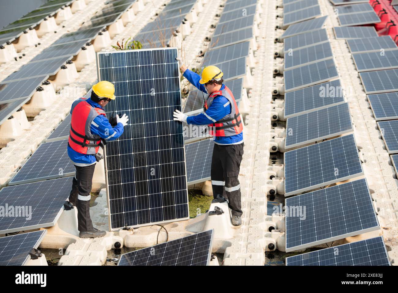 Photovoltaik-Ingenieure arbeiten an schwimmender Photovoltaik. Prüfen und reparieren Sie die auf dem Wasser schwimmenden Solarpaneele. Stockfoto