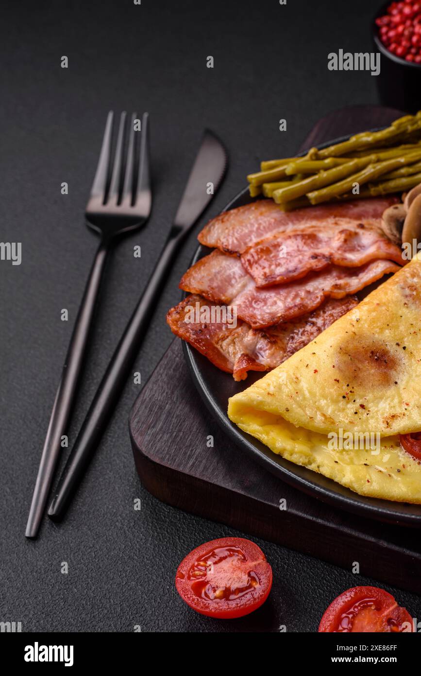 Köstliches frisches Omelett mit Kirschtomaten, Speck, Spargel und Gewürzen Stockfoto