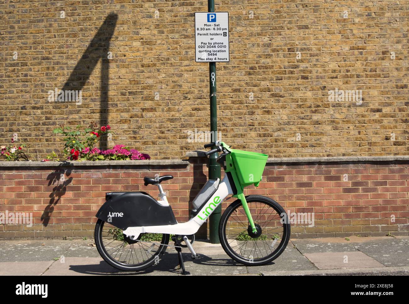 Leihfahrrad aus Kalk, geparkt auf einem Fußweg unter einem Schild mit Parkbeschränkungen für Fahrzeuge, in twickenham, middlesex, england Stockfoto