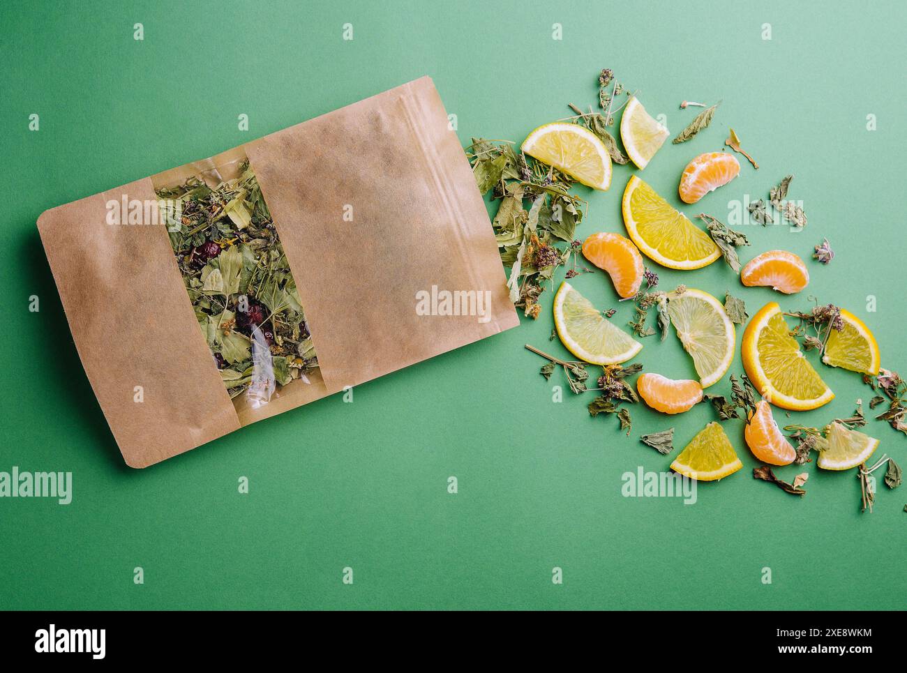 Blatttee aus einer Papierpackung mit Orangen- und Mandarinenscheiben Stockfoto