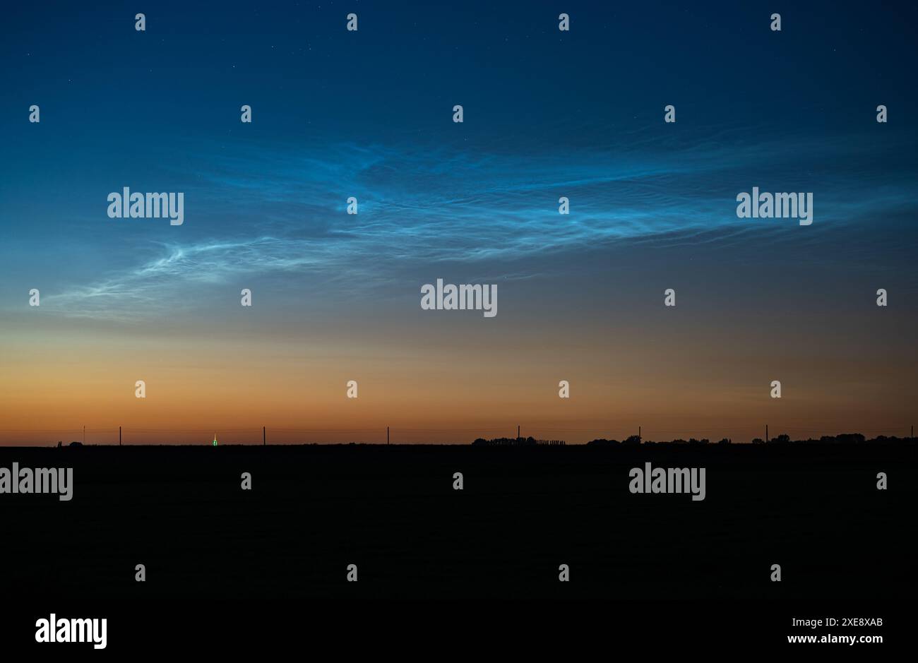 Leuchtend silbrig-blaue Nachtwolken (NLC) heben sich in einer Mittsommernacht vom Abendhimmel ab Stockfoto