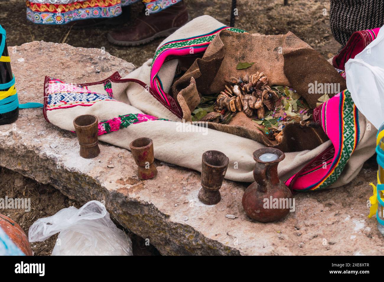 Traditionelles Ritual der Zahlung an die Erde mit Kokablättern und Chicha de jora in den Anden der Bergkette an einem sonnigen Tag Stockfoto