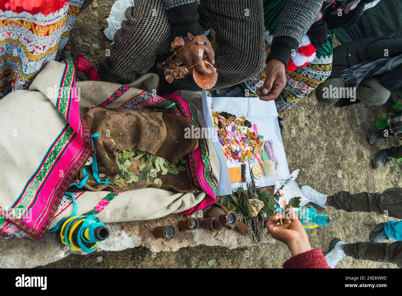 Traditionelles Ritual der Zahlung an die Erde mit Kokablättern und Chicha de jora in den Anden der Bergkette an einem sonnigen Tag Stockfoto