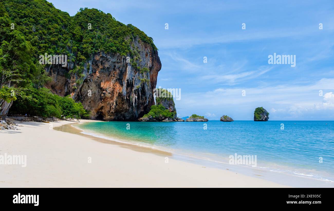 Ein tropischer Strand mit einem großen Felsen im Hintergrund Stockfoto
