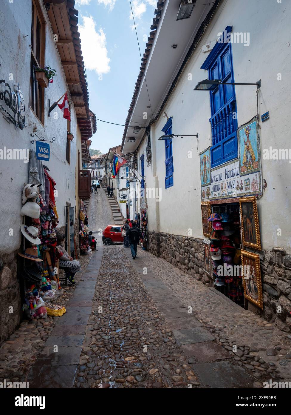 Cusco, Perú; 9. August 2023: Geschäfte in einer Fußgängerzone der Kolonialstraße mit Steinböden, engen und weiß bemalten Häusern Stockfoto