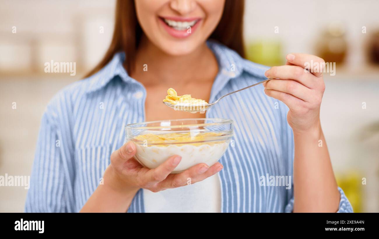 Mädchen essen Joghurt mit Flocken zum Frühstück Stockfoto